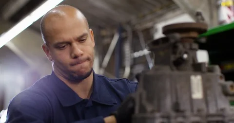 4K Mechanic in auto repairs workshop concentrating while repairing car engine pa Stock Footage 103898761