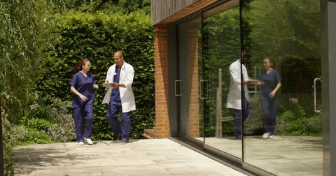 4K Medical workers with digital tablet arguing outside modern hospital building Stock Footage 81259070
