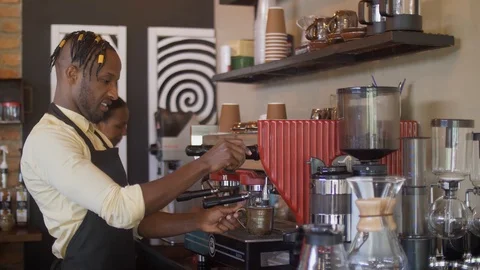 4k medium close up of friendly workers standing behind the counter diong coffee. Stockbeeldmateriaal 111339717