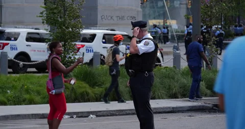 4K MEDIUM FULL OF COP AND WOMAN ARGUING DURING PROTEST Stock Footage 131458119