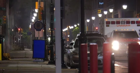 4K MEDIUM SHOT EMPTY CITY STREET AT NIGHT PAN TO AMBULANCE DRIVING Stock Footage 131127135