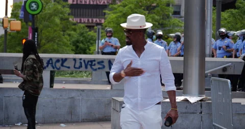 4K MEDIUM SHOT OF PROTEST LEADER RALLYING IN FRONT OF COPS Stock Footage 131458535