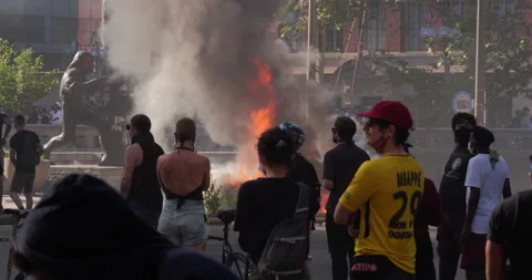 4K MEDIUM SHOT WITH PROTESTERS AND CAR ON FIRE Stock Footage 131453104