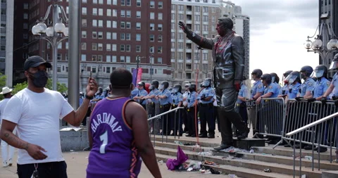 4K MEDIUM SHOT OF PROTESTORS TAKING PHOTOS OF VANDALIZED FRANK RIZZO STATUE Stock Footage 131458281
