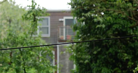 4K MEDIUM SHOT RACK FOCUS FROM WIRE TO A BRICK BUILDING WITH WINDOWS IN THE RAIN Stock Footage 131128488