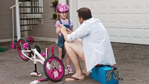 4k medium steadicam shot of father explaining how to fix a bicycle flat with dau Stock Footage 201093858