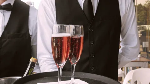 4k medium steadicam video of waiter and champagne glasses on a tray, walking to Stock Footage 201095777