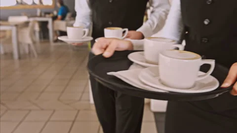4k medium steadicam video of waiter and coffee on a tray, walking to a customer Stock Footage 201095976