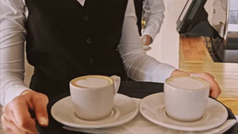 4k medium steadicam video of waiter and coffee on a tray, walking to a customer Stock Footage 201096908