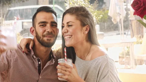 4k medium video of multicultural dating couple drinking milkshakes in cafe. Stock Footage 201095584