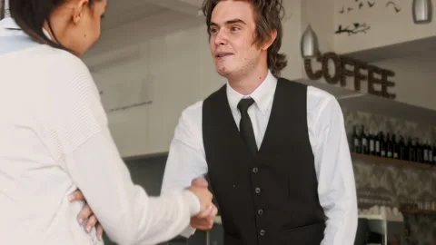 4k medium video of waiter/ hostess welcoming customer and showing them where the Видео 201094271