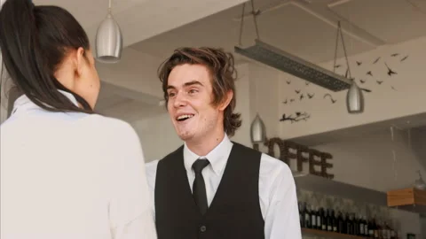 4k medium video of waiter/ hostess welcoming customer and showing them where the Vidéo 201096944