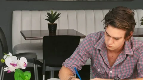 4k medium video of young and focused student writing notes in local study hangou Stock Footage 201095095