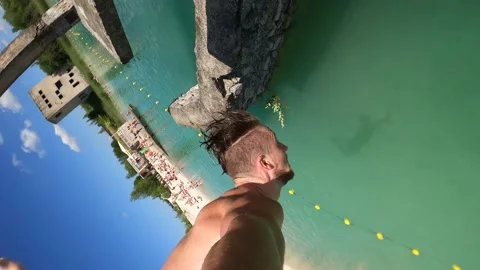 4K of men diving and doing a backflip into Rummu Quarry next to abandoned prison Vidéo 157013215