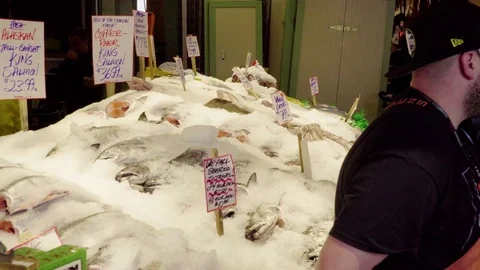 4K Men selling fish at Pikes Places market in Seattle Washington during day Stock Footage 73503057