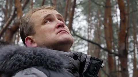 4k middle aged man looks birds at the winter pine forest close-up Stock Footage 84163070