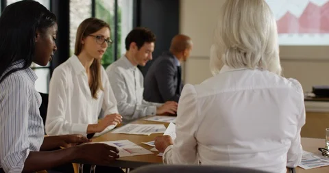 4K Mixed ethnicity corporate group discussing business report in a meeting Stock Footage 101404650