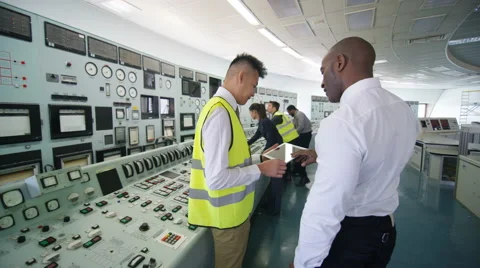 4K Mixed ethnicity team of engineers working in power station control room Stock Footage