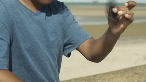 4K Mixed Race Young Boy Spinning Toy at Eye Level on Beach Vidéo 75956218