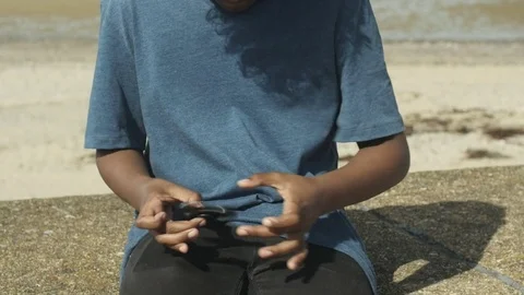 4K Mixed Race Young Boy Passing His Spinning Toy Hand to Hand Stock Footage 75956257