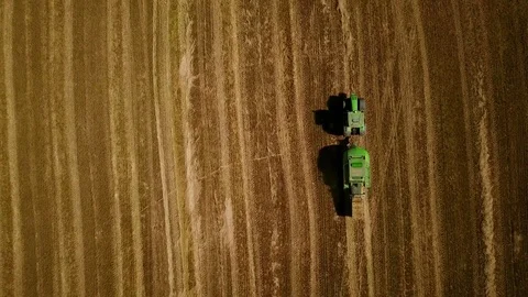 4K. Modern tractor makes haystacks on the field after harvesting. Aerial view. 動画素材 79604922