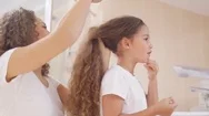 4K Mother Styling Her Young Daughters Hair In The Bathroom In The Morning Stock Footage
