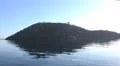 4k Mountain island mirroring in calm Flores Sea while shipping 4k or 4k+ Resolution