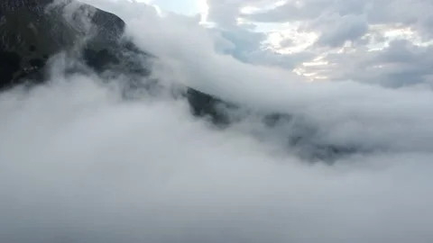 4K of a mountain shrouded in captivating clouds Stock Footage 218609373