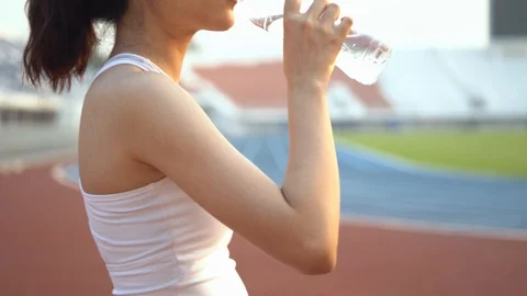 4k Move camera to Young Asian teenage girl drink water from plastic bottle Stock Footage 124364767