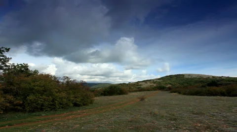 4K. Movement of the clouds on the mountain on a dirt road.  Stock Footage 32153071