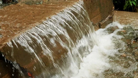 4K. Nature river waterfall that overflows over a forest road after a heavy rain Video stock 211339913