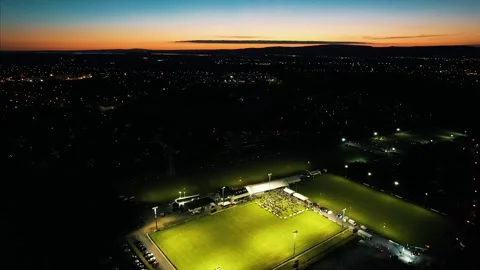 4K Night Drone Flying Over Lit Rugby Pitch Towards Limerick City, Ireland Stock Footage 301580740
