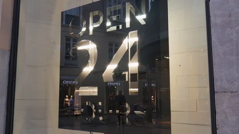 4k night static shot of a 24 hour open sign in a shop window with reflections. Stock Footage 122643868