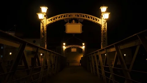 4k night static shot of an ancient metallic pedestrian bridge with silhouettes Stock Footage 124074135