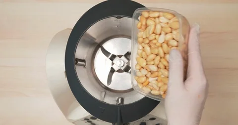 4K - Nuts are filled up into a grinder. Close-up Stock Footage 106890359