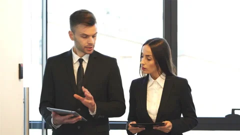 4K. Office work day . Pretty brunette,  businesswoman  and businessman  Stock-Footage 98627009