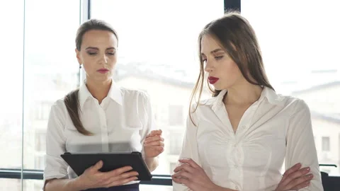 4К. Office work. Two  business woman  working by tablet and discuss.  Stockbeeldmateriaal 102836335