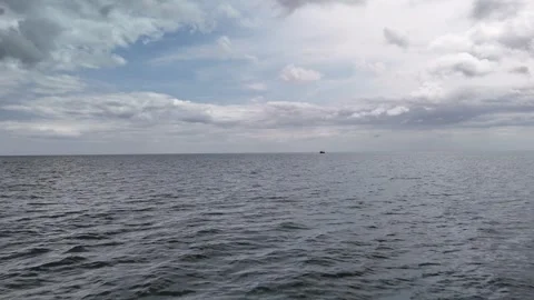 4K Open Sea View with Small Boat and Cloudy Sky Vídeos de archivo 333411653