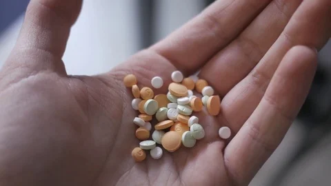 4K Opening Hand Full of Medication Drugs Pills Stock Footage 73145271