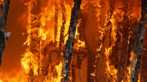 4K Orange flames engulfing a small building. House wall being burned down by a Stock Footage 232337615
