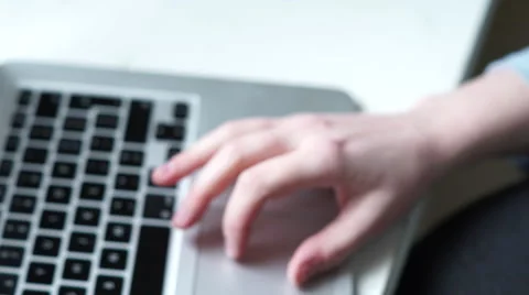 4K Out of focus hand types on silver computer with black keys Stock Footage 62948405