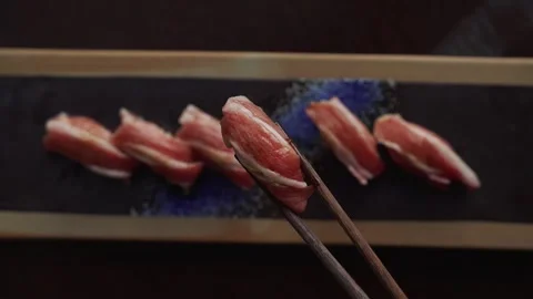 4K overhead video chopstick pulling up bluefin belly tuna nigiri in a plate Stock Footage 315123287