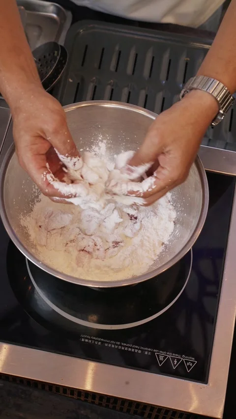 4K overhead video snapper meat coated with flour in bowl part 1 - vertical Stock Footage 315124040