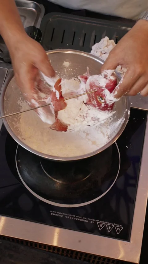 4K overhead video whole snapper coated with flour in bowl part 2 - vertical Stock Footage 315124077