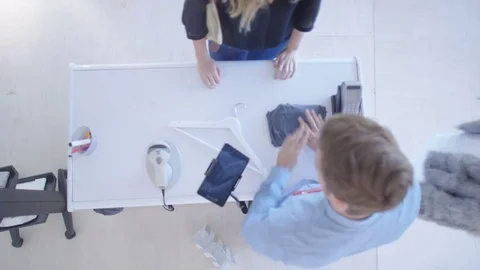 4K Overhead view of customer making payment with smartphone in clothing store 스톡 동영상 70721551
