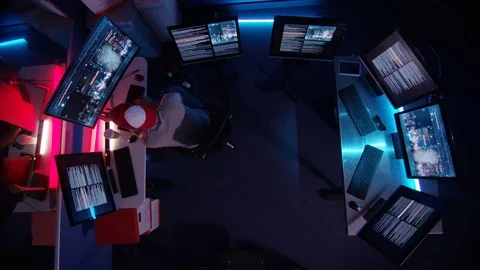 4K Overhead view looking down, computer hacker surrounded by computer screens Vidéo 73402845