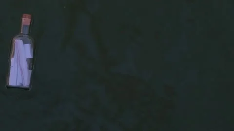 4K Overhead View of a Message in a Bottle Floating on the Ocean Stock Footage 221170660