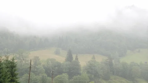 4K. Overview of a mountain slope full of fog during the rain. 動画素材 211339671