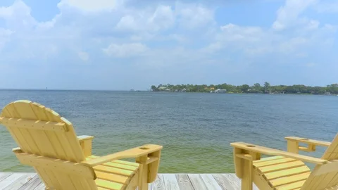 4K Pan Behind Two Deck Chairs Looking Out to the Water Stock-Footage 109229383