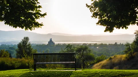 4K pan up to a bench overlooking a valley town Video stock 45705112